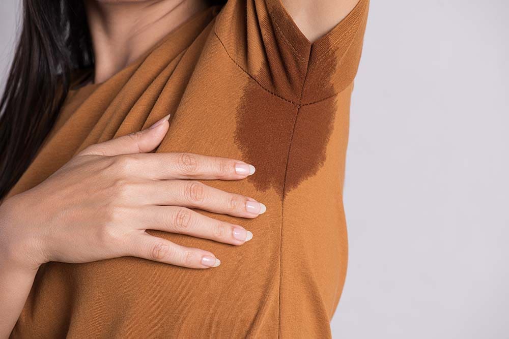 Close-up woman with hyperhidrosis sweating.